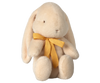 The PRE-ORDER: Maileg Plush Bunny - Medium Cream, made from recycled polyester, sits upright with long floppy ears. It has a yellow ribbon bow around its neck against a neutral background and ships in February.