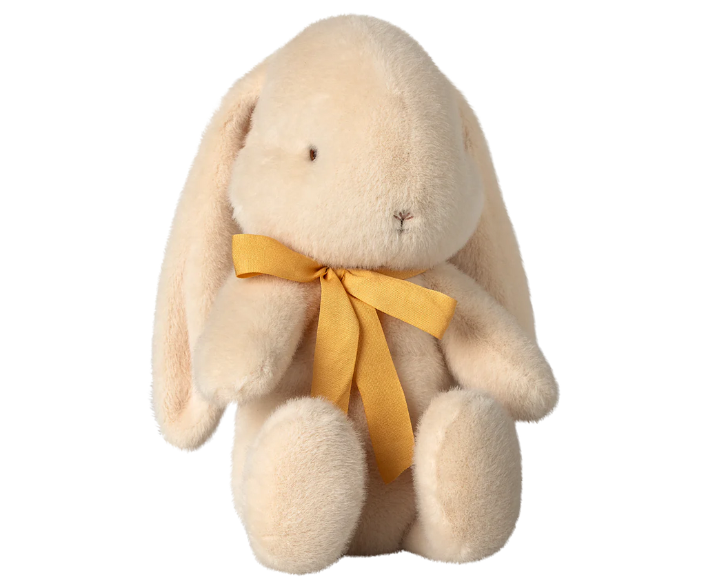 The PRE-ORDER: Maileg Plush Bunny - Medium Cream, made from recycled polyester, sits upright with long floppy ears. It has a yellow ribbon bow around its neck against a neutral background and ships in February.