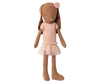The Maileg Bunny, Size 1, in chocolate brown wears a rose ballet suit and skirt, standing upright like a sweet dancer with a pink flower headband against a blurred background.