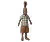 The Maileg Rabbit, Size 3 - Brown, stands upright in a blue and brown plaid shirt with brown shorts. This plush toy features long ears, stitched facial details, and a soft fabric body—perfect for cuddling or imaginative play.