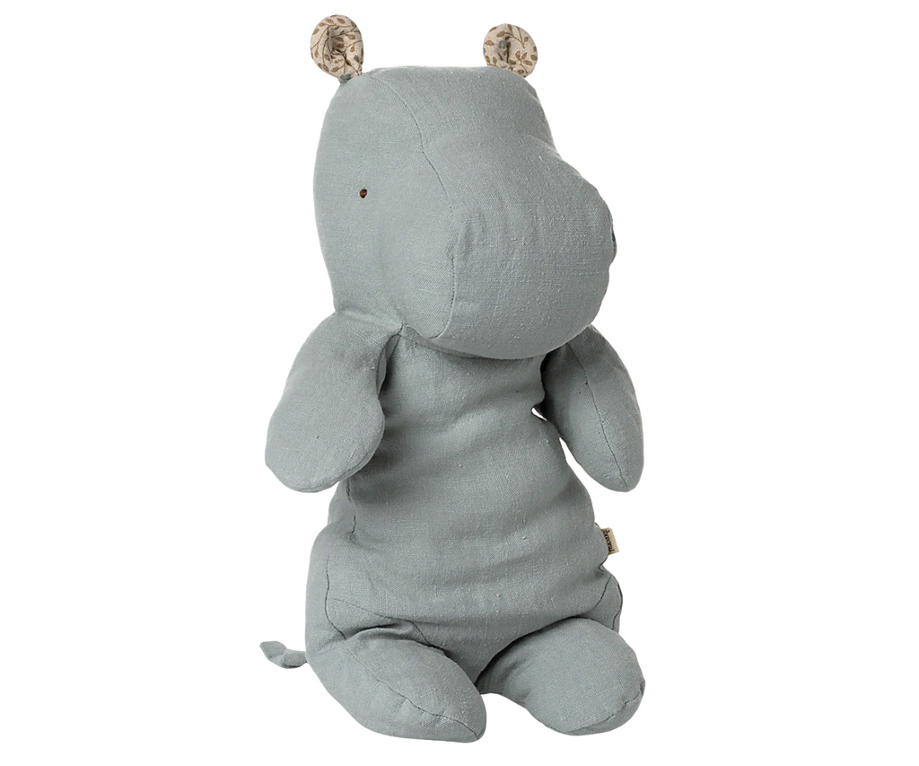 The Maileg Medium Hippo Stuffed Animal in blue, from the Safari friends collection, features soft linen fabric, simple stitched eyes, and small round ears with striped accents. The hippo sits upright against a plain background.