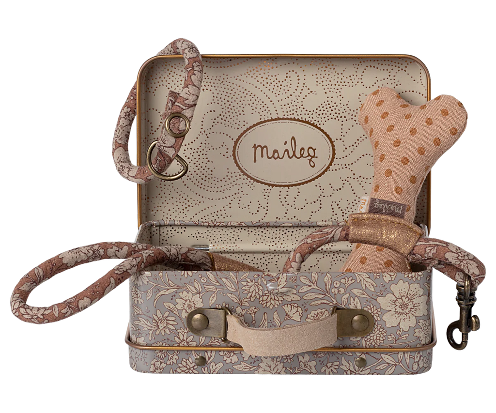 The Maileg Puppy Supply Accessories - Rose set includes a small metal suitcase with a charming Maileg print, and features a pink polka-dot dog bone toy, matching leash, and collar—perfect for your plush dog. "Maileg" is labeled inside the lid.