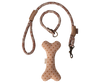 The Maileg Puppy Supply Accessories - Rose includes a pink and beige dog leash next to a beige bone-shaped toy with brown polka dots, perfect for your plush dog, all set on a plain background.