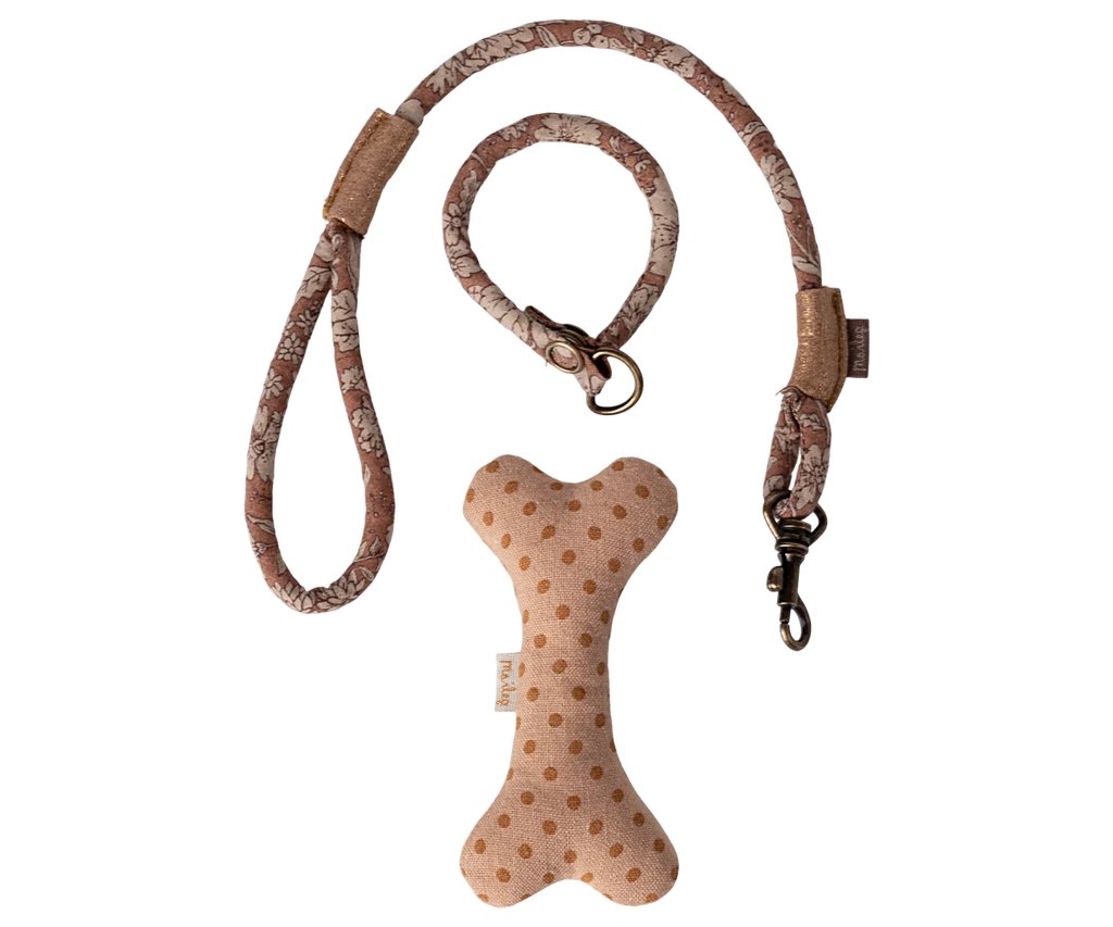 The Maileg Puppy Supply Accessories - Rose includes a pink and beige dog leash next to a beige bone-shaped toy with brown polka dots, perfect for your plush dog, all set on a plain background.
