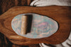 The Flower Roller - Eco Pattern Playdough Roller features elegant floral engravings and rests atop a marbled pastel clay slab imprinted with flower designs, all displayed on a wooden board with a textured cloth nearby—perfect for sensory play and inspiring creative adventures with eco-friendly playdough tools.