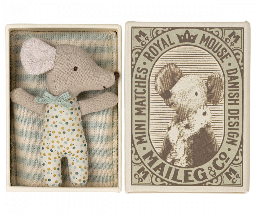 A small stuffed toy mouse in polka-dotted pajamas is nestled in a box lined with striped fabric. The box features a vintage-style illustration of Mom Mouse wearing a crown, labeled "Royal Mouse, Danish Design, Maileg & Co. Mini Matches," making it the perfect addition to any Maileg Nursery Room Starter Set.