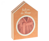 An orange house-shaped box with the text "Cabine de Plage" on it. The circular window reveals a glimpse of the Maileg Extra Clothing: Bathrobe - Coral inside. The box has a simple, charming design.
