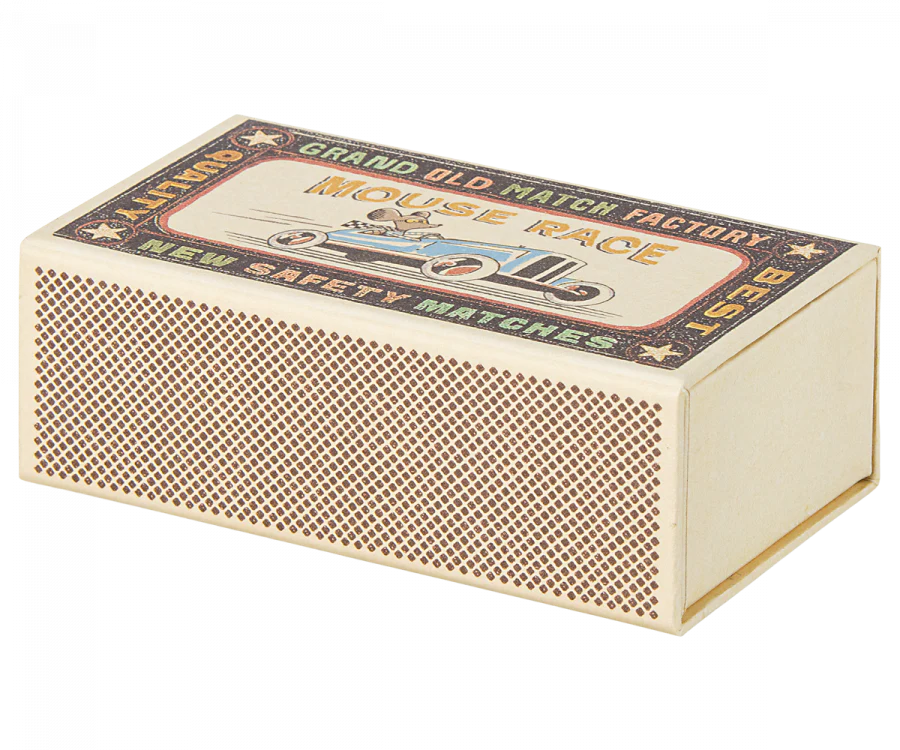 Vintage matchbox with intricate design labeled "Grand Old Match Factory" featuring ornate text and borders, transformed into a Maileg Big Brother Mouse in Box bed, isolated on a white background.