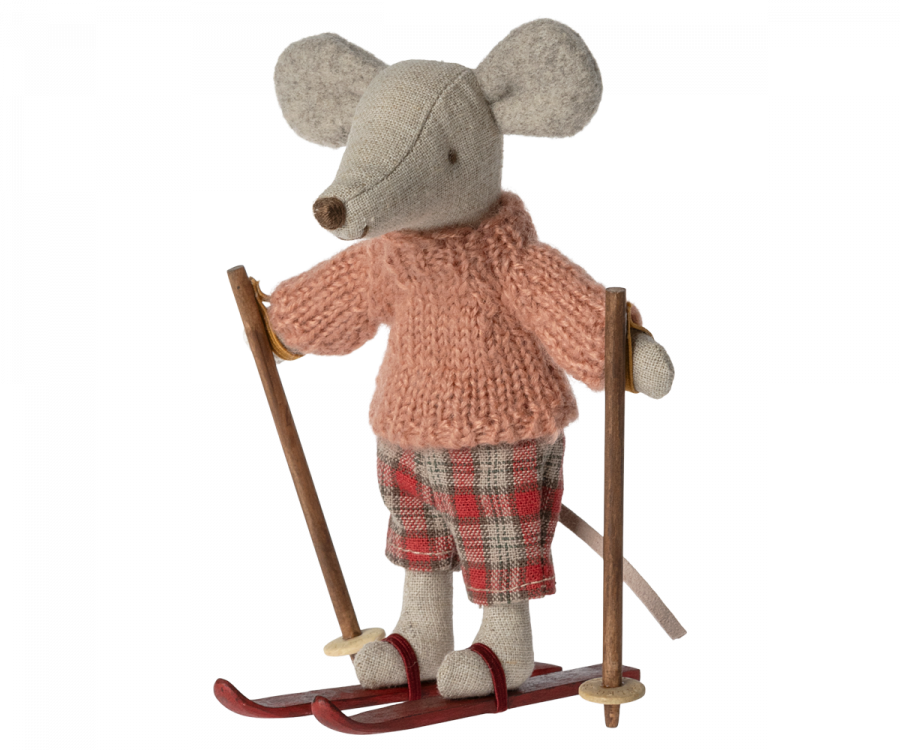 A small, stuffed Maileg Christmas Winter Mouse With Ski Set, Big Sister on skis, dressed in a knitted pink sweater and plaid pants. This charming winter toy, holding ski poles, appears ready for a snowy adventure.