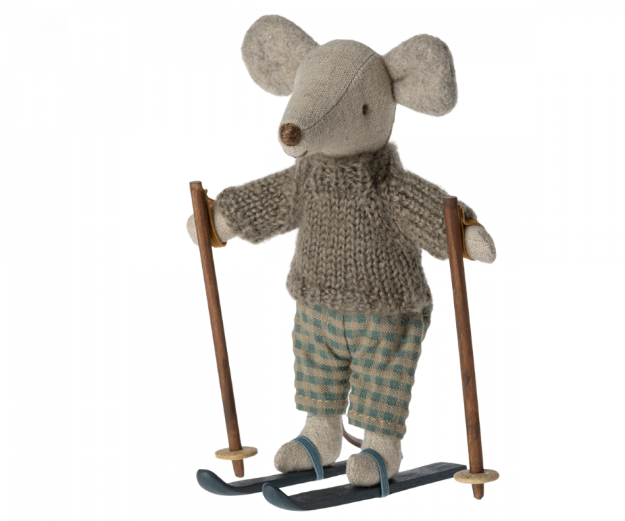 A small stuffed mouse doll, part of the Maileg Christmas Winter Mouse With Ski Set, Big Brother, is dressed in a knitted gray sweater and checked green pants. It is holding wooden ski poles and has skis attached to its feet, ready for a ski adventure. Made from recycled polyester, this toy combines fun with sustainability.