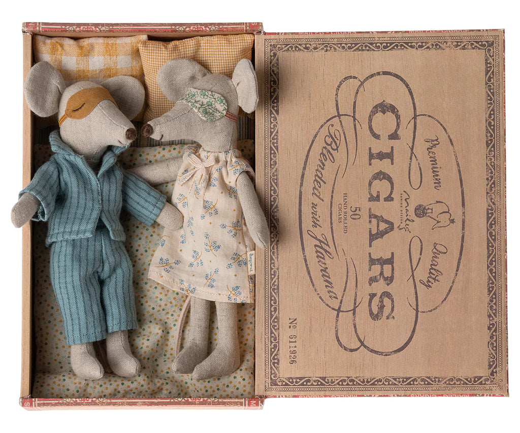Two Maileg Mum & Dad Mice in Cigar Box, one dressed in blue nightwear and the other in a floral night dress, lying in a vintage cigar box bed with charming old-style typography on its lid.