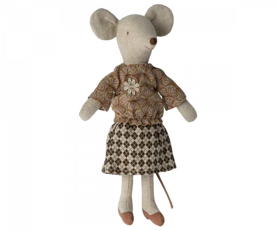 A Maileg Extra Clothing: Blouse And Skirt For Grandma Mouse toy mouse wearing grandma mouse clothes: a flower brooch-adorned patterned top, a checkered skirt, and brown shoes. The mouse has large round ears and a long tail. The fabric and design give the toy a handmade, vintage look.