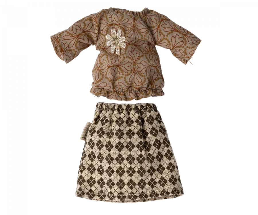 The Maileg Extra Clothing: Blouse And Skirt For Grandma Mouse consists of a long-sleeved top with a brown and beige floral pattern adorned with a white lace flower brooch, paired with a beige and black argyle-patterned classic skirt.