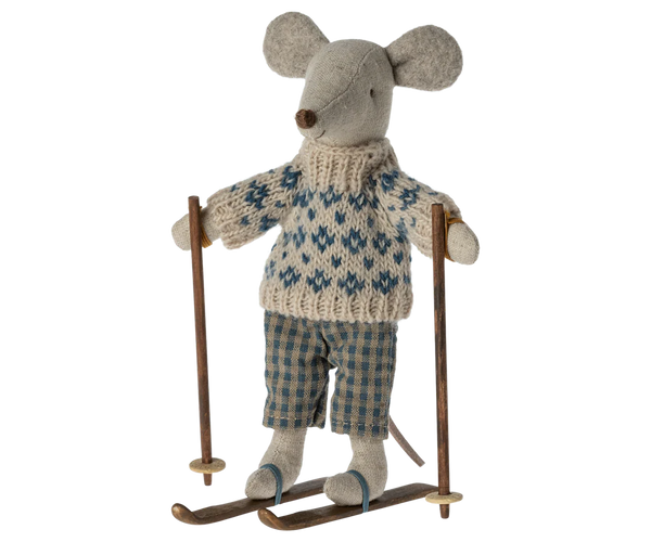 The Maileg Winter Mouse with Ski Set, Dad, features a dad mouse dressed in a knitted sweater and plaid pants, standing on wooden skis and holding two ski poles.
