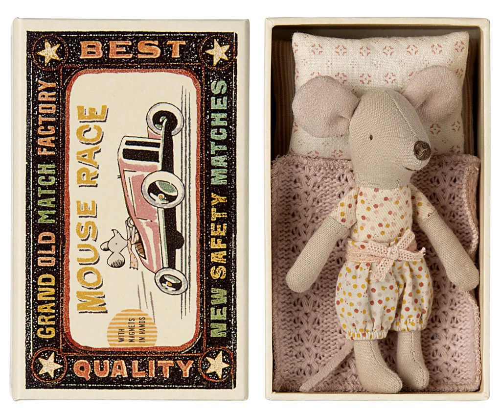 The Maileg Little Sister Bedroom Starter Set features a stuffed toy mouse in a polka dot outfit lying in a miniature bed with a pink blanket and white pillow, all within a vintage-style matchbox labeled "Mouse Race." Perfect for Maileg enthusiasts, but beware of potential choking hazards.