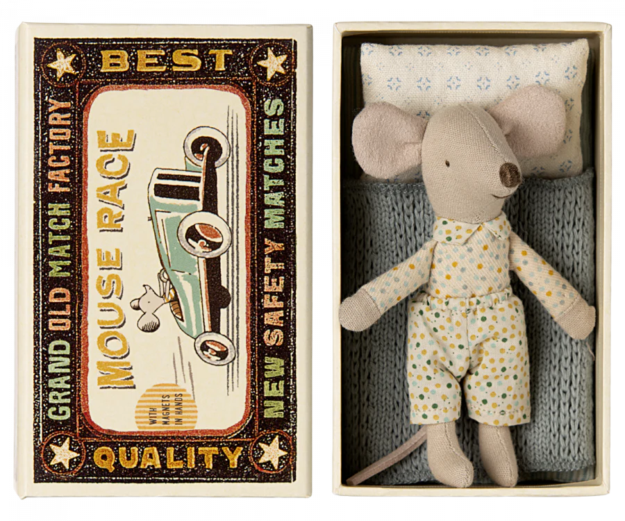 Vintage Maileg matchbox with a colorful graphic of a mouse riding an old-fashioned race car on the left. A small stuffed mouse toy wearing a floral outfit in an Easter Basket Set bed on the right.