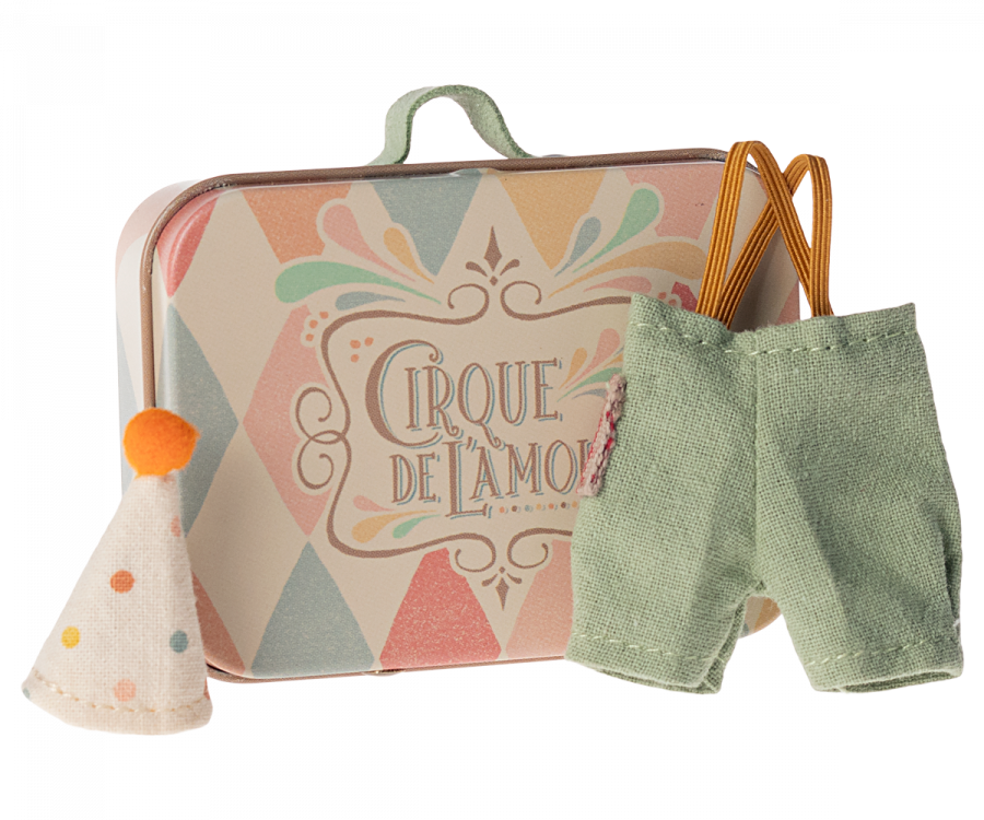 A small, decorative suitcase featuring the text "Cirque de l'Amour" along with pastel-colored patterns. Next to the suitcase are a tiny polka-dotted clown hat with an orange pom-pom and a pair of green overalls, making it a delightful travel-friendly toy accessory set, known as Maileg Clown Clothes In Suitcase, Little Brother Mouse.