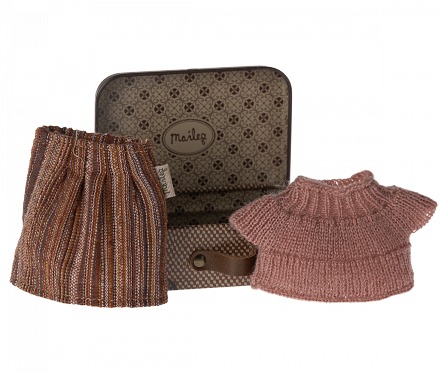 A small metal suitcase is open, revealing a striped skirt and a pink knitted sweater inside. The suitcase, perfect for Maileg Knitted Blouse And Skirt In Suitcase, Grandma Mouse or any holiday toy, features a floral design on the interior and has the label "Maileg" on the lid.