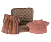 A small, open suitcase from the Maileg Set - Tea Party With Grandparents displays a tiny pink knitted sweater and a striped skirt with shades of brown and orange. The suitcase has a patterned interior with a "Maileg" logo on the inside lid, perfect for carrying your Grandparents Mice. A small brown strap is attached to the suitcase.