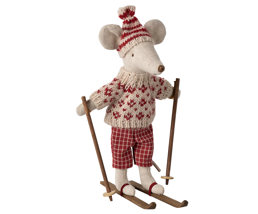 The Maileg Ski Lounge Set features an adorable stuffed mouse toy outfitted in a cozy knitted red and white sweater, a matching hat, and checkered pants. The mouse stands confidently on skis with wooden poles, making it perfect for display. However, please be aware that it contains small parts and may pose a choking hazard for young children.