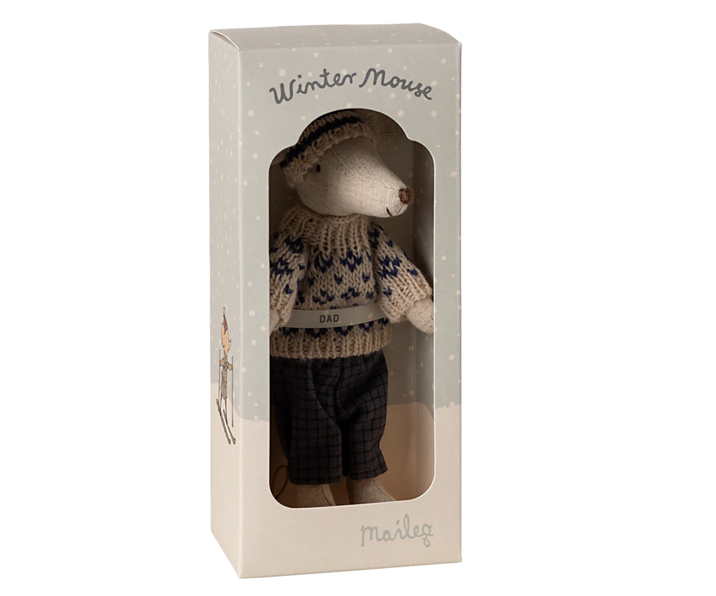 The Maileg Winter Mouse with Ski Set, Dad - Blue is presented inside a box marked "Winter Mouse." This charming plush toy mouse is dressed in a patterned sweater featuring "DAD," dark pants, and a beanie, ideal for complementing any ski accessories.