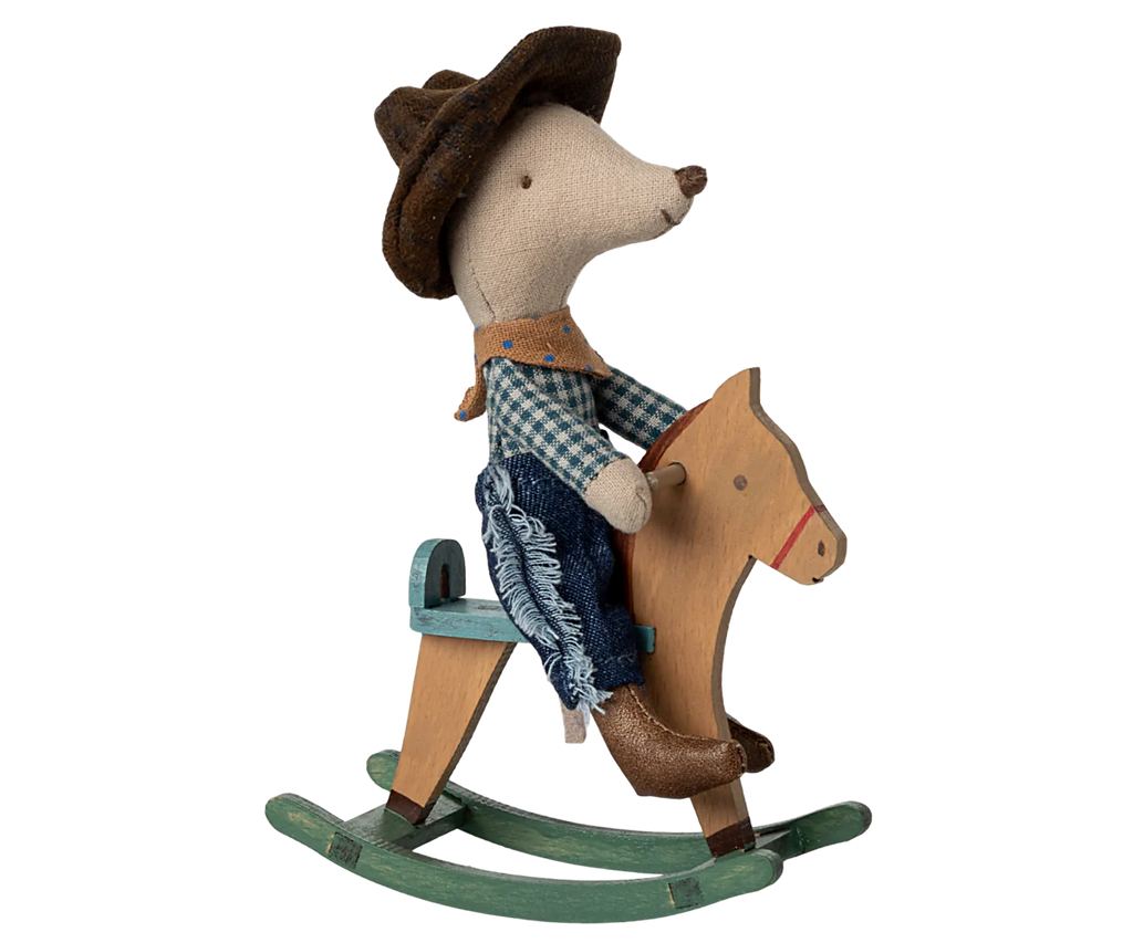 The Maileg Cowboy Mouse On Rocking Horse, Little Brother—wearing a brown hat, blue checkered shirt, and jeans—sits on a green and brown rocker, adding adventurous charm to any play set. Ships in one week.