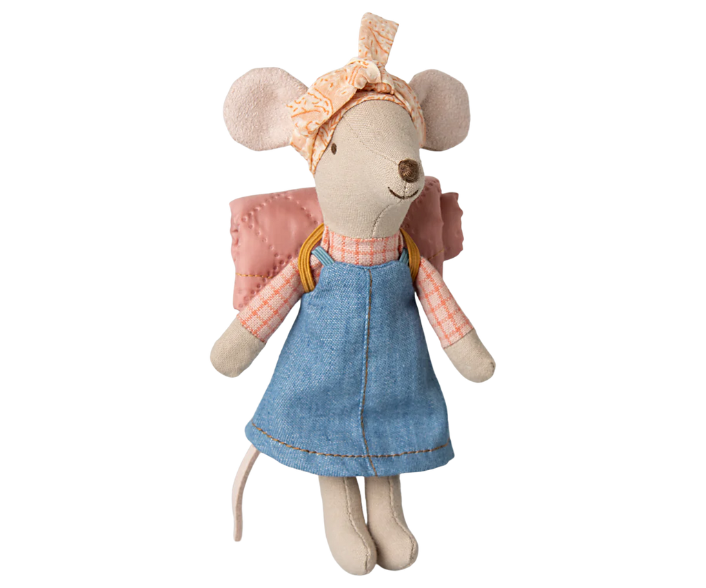 The Maileg Hiker Mouse, part of the hiker collection, wears a denim dress and pink checkered shirt with a stylish headscarf and backpack. Made of soft cotton, this adventurous stuffed toy stands smiling against a pastel-colored background.