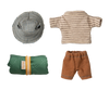 A flat lay includes a checkered sun hat, a striped short-sleeve shirt, brown shorts, and a rolled green sleeping bag with a yellow band, perfect for a doll-sized hiking trip from the Hiker Collection of Maileg Hiker Mouse With Thing Striped Shirt - Big Brother.