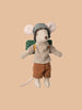 A Maileg Big Brother Horseback Adventure Set toy, dressed in a blue checked hat, striped shirt, brown shorts, and a green backpack, is posed against a plain beige background.