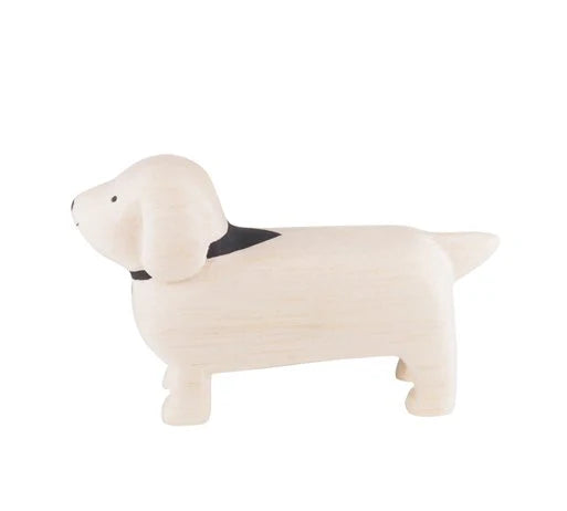 A Handmade Tiny Wooden Animals - White Dachshund Dog with a black collar. Handcrafted by skilled artisans, this dog figure stands with a slightly curved tail and minimal detailing, giving it a cute and minimalist look. The plain white background highlights its handmade charm.