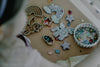 A child sits near a tray featuring the Unicorn Cutter Set - Eco Playdough Tool, surrounded by colorful beads and star-shaped clay creations. The scene is vibrant and imaginative, making it perfect for creative sensory play.