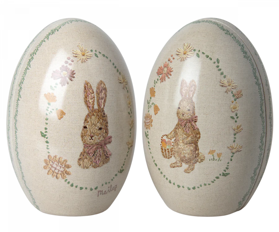 The Maileg Easter Egg - Set of Two (Pink) features intricately decorated metal eggs with rabbit images, one holding a basket. Adorned with Dorthe Mailil's pastel floral patterns, these Easter eggs offer an enchanting visual delight. Ships in about one week.