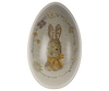 An oval-shaped Maileg Easter Egg featuring a detailed depiction of a brown bunny with a bow around its neck, surrounded by floral accents, set against a beige background.