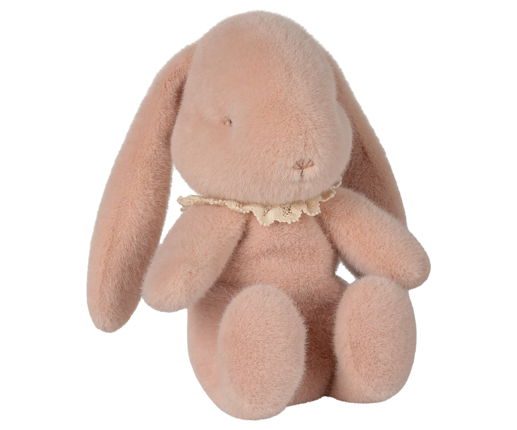 The PRE-ORDER: Maileg Easter Egg With Bunny - Powder features a soft, pink plush bunny with droopy ears and a lace collar, filled with eco-friendly recycled polyester. It is posed against a neutral background with its head gently tilted to the side. Ships in February.