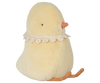 The PRE-ORDER: Maileg Easter Egg With Chick, available for February shipping, is a plush, light yellow bird toy made from recycled polyester. It has an orange beak and feet, a lace collar, and is in a sitting position, with its soft texture suitable for all ages.