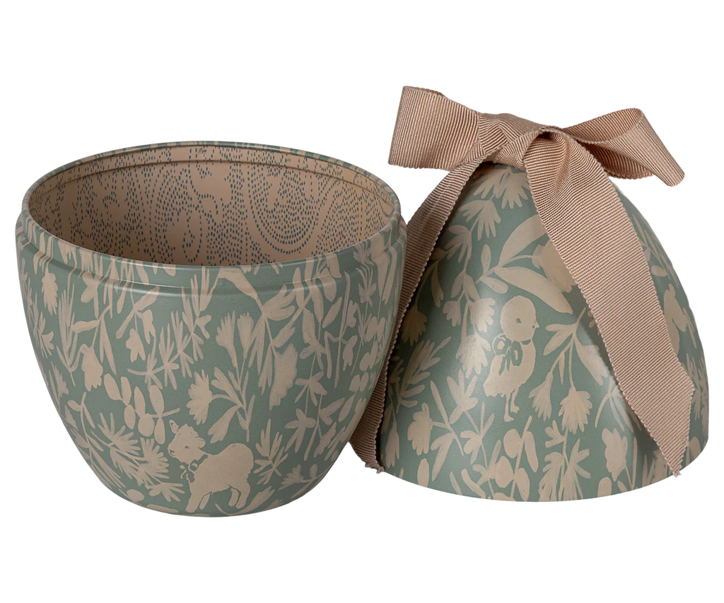 The PRE-ORDER: Maileg Easter Egg - Mint, available in February, is a round metal box with nature-inspired animal and plant designs in soft green and cream. An intricate pattern decorates both inside and outside; the lid is tied with a ribbon for an exclusive look.