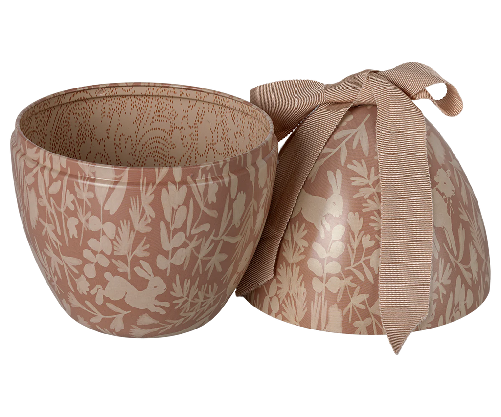 The Maileg Easter Egg - Powder is a decorative metal bowl with a matching lid, showcasing white floral and rabbit designs on a soft brown background. Topped with an elegant light brown ribbon bow, its interior features a subtle, intricate pattern.