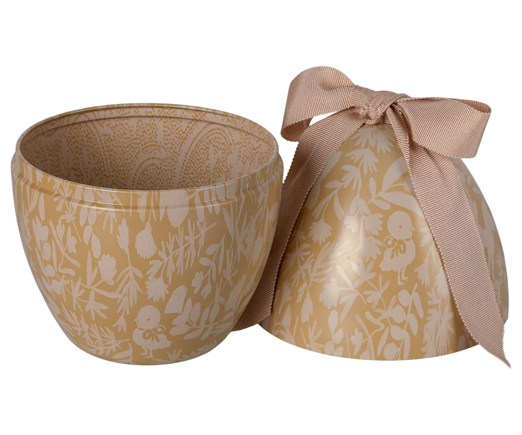 The PRE-ORDER: Maileg Easter Egg - Cream Yellow (Ships in February) is an elegant, egg-shaped container with a floral print in beige and white. Its lid with a beige ribbon bow complements the open base, revealing a spacious interior for an exclusive look.