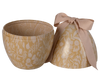 The Maileg Easter Egg, Medium - Cream Yellow, is a decorative egg-shaped container with a floral pattern and beige tones. It comes open with the lid beside it, adorned with a large beige ribbon bow on top.