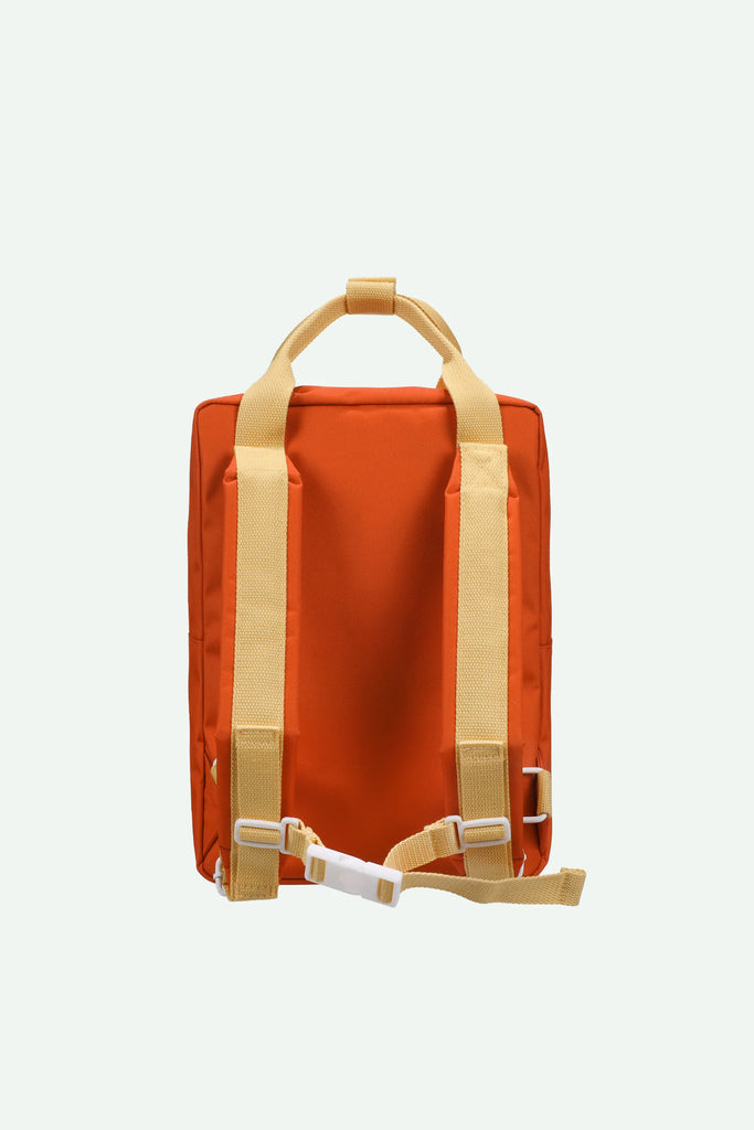 A Sticky Lemon Backpack Medium | Envelope | Campfire Orange is displayed from the back against a plain light background, featuring a medium-sized orange body with yellow straps and handles, white plastic buckles, and a waterproof lining made from recycled PET.