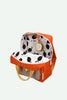 The Sticky Lemon Backpack Medium | Envelope | Campfire Orange is an open, medium-sized orange backpack with yellow handles and a white interior lining adorned with a black leaf pattern. Made from recycled PET bottles, it includes a yellow tag attached inside and features a mesh front pocket with a button closure.