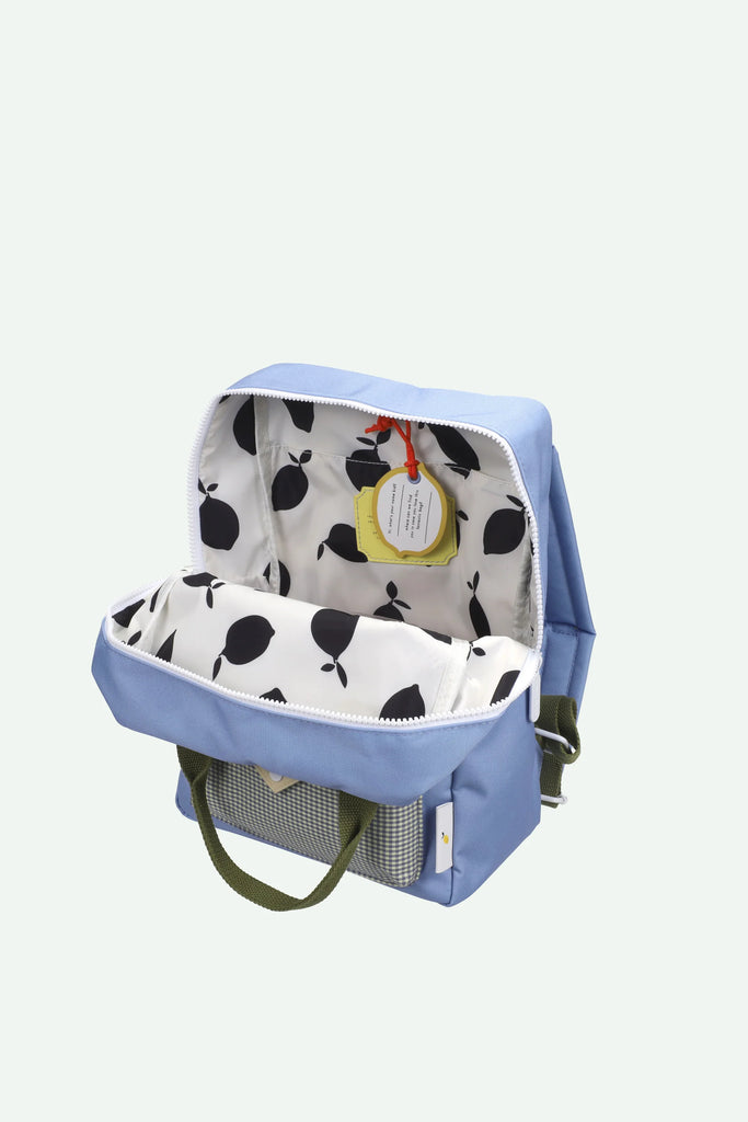 A Sticky Lemon Backpack Medium | Envelope | Cloud Blue features a light blue design with green handles and unzips to reveal a white interior lining decorated with a black leaf pattern and a small yellow tag on the inside pocket. This waterproof kids backpack—crafted from recycled PET—combines style, functionality, and sustainability.
