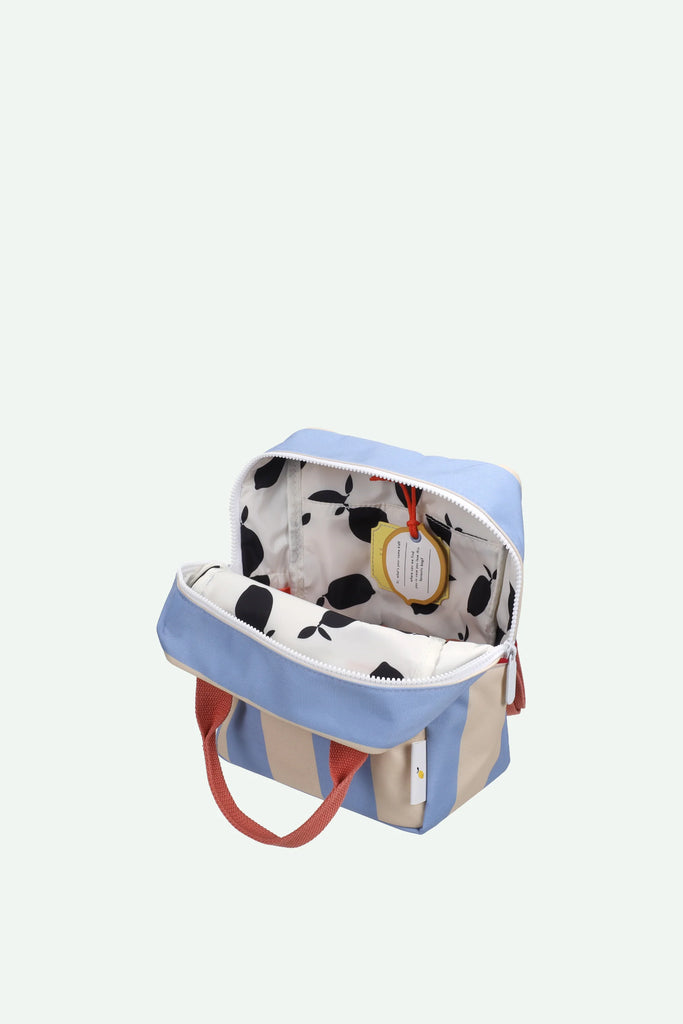 The Sticky Lemon Backpack Small | Stripes | Cloud Blue + Twiggy Beige is a small recycled PET bag with blue and beige stripes, red handles, a white waterproof lining with black leaves, and a yellow tag inside.