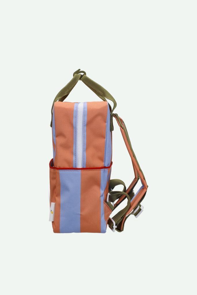 A side view of the Sticky Lemon Backpack Medium | Stripes | Cloud Blue + Maple Whirl, featuring vertical blue and orange stripes, olive green straps, a front pocket, and a central zipper; crafted from recycled PET bottles with a waterproof lining.