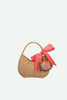 A charming Sticky Lemon Wicker Basket | Lemon Tree featuring a curved handle, adorned with a large red gingham bow and a small embroidered strawberry bag charm hanging from the handle—a delightful kids accessory for any outing.