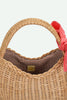 The Sticky Lemon Wicker Basket | Lemon Tree is a delightful kids accessory crafted from woven straw, featuring a rounded handle, brown checkered fabric lining, and a playful red gingham bow tied to one side—evoking the charm of a classic wicker basket and adding a whimsical touch to any outing.