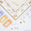 Monopoly Bianco Edition game board featuring white property spaces, gold foil-stamped accents, paper money, dice, and small wooden tokens.
