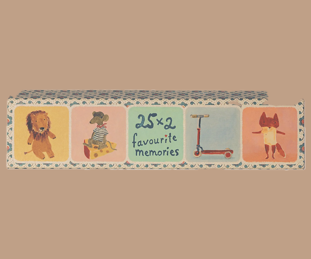 The Maileg Memory Game comes in an illustrated box titled "25 x 2 Favourite Memories," featuring whimsical Dorthe Mailil illustrations, including a lion, an elephant in a striped shirt with a toy box, a red scooter, and a fox in a dress. A light brown background enhances the charm of this enchanting memory game.