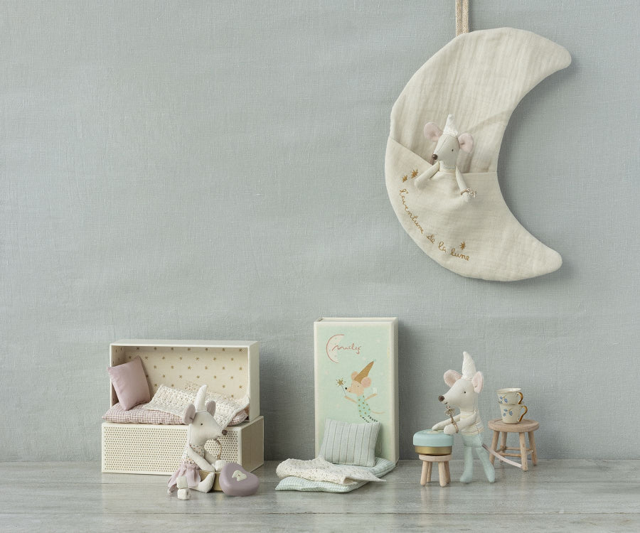 A whimsical nursery scene with adorable mouse plush toys in various setups: a mouse on a small bed, a mouse sitting on a stool, and a Maileg Moon Decoration, L'aventure De La Lune perfect for tooth fairy storage. The background has a light, calming color palette with pastel hues and soft textures.