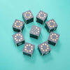 Nine Uncle Goose Moon Phase Blocks—blue cubes featuring gold dots and detailed moon phase icons—are arranged in a circle on a teal background.
